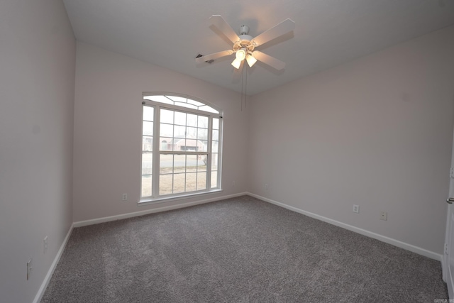 carpeted spare room featuring baseboards and ceiling fan