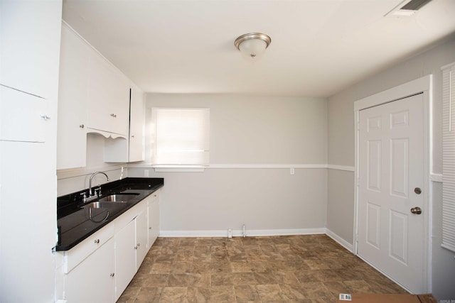2919 W 27th St, Little Rock, AR 72204 - kitchen with a sink, stone finish floor, visible vents, and white cabinets
