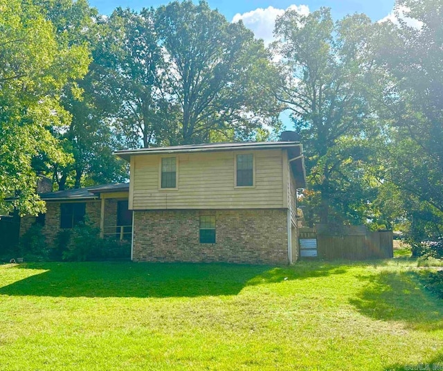 view of property exterior with a yard and brick siding