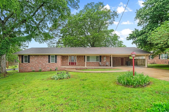 ranch-style home featuring concrete driveway, a front yard, an attached carport, and brick siding