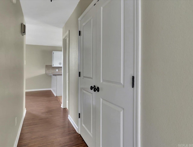 hall with baseboards and dark wood-style floors