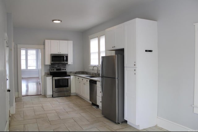 315 W 22nd St, Little Rock, AR 72206 - kitchen featuring a sink, stainless steel appliances, baseboards, and white cabinets