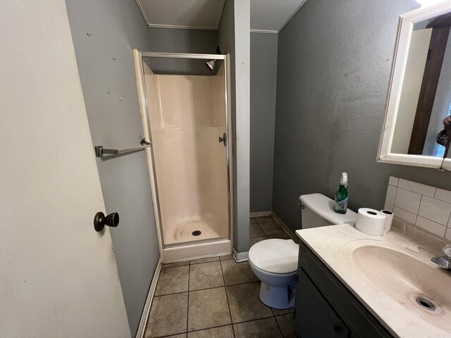 full bathroom featuring toilet, a stall shower, tile patterned floors, baseboards, and vanity