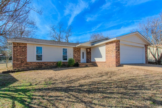 single story home with driveway, brick siding, an attached garage, and a front yard