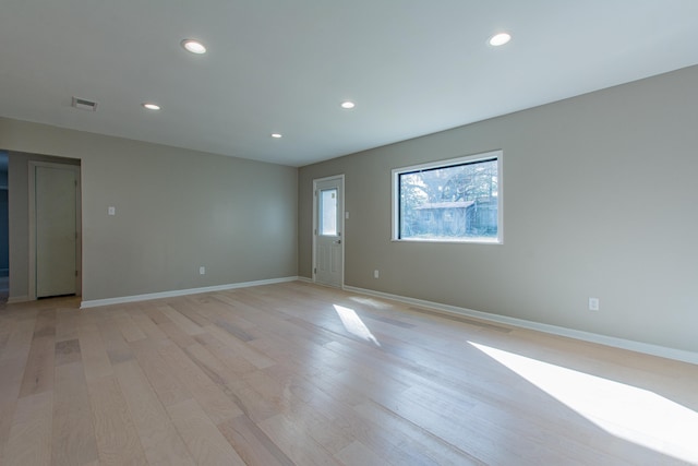 spare room featuring baseboards, light wood-type flooring, visible vents, and recessed lighting