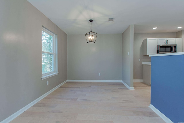 unfurnished dining area with baseboards, light wood-style floors, visible vents, and recessed lighting