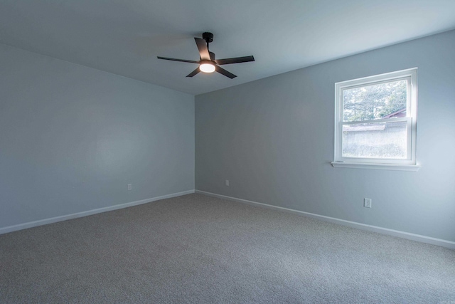 carpeted spare room with baseboards and ceiling fan