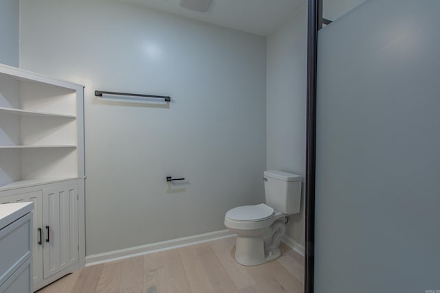 bathroom with toilet, baseboards, vanity, and wood finished floors