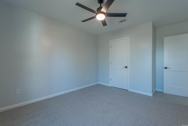 carpeted empty room with ceiling fan, baseboards, and visible vents