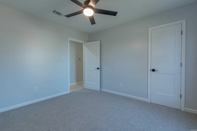 unfurnished bedroom featuring light colored carpet, baseboards, a ceiling fan, and visible vents