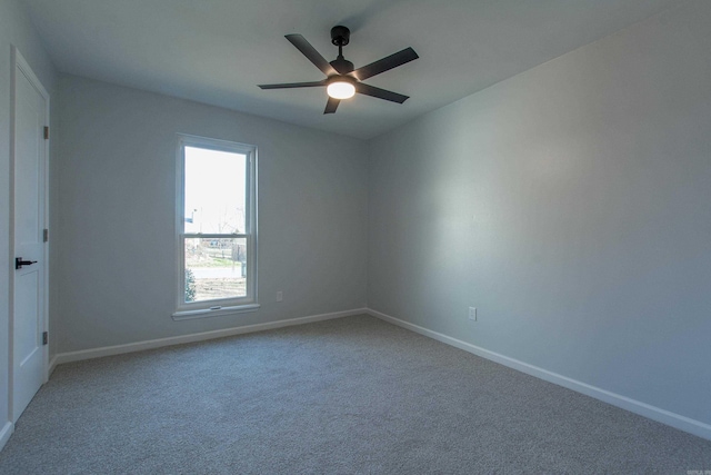 carpeted empty room featuring baseboards and ceiling fan