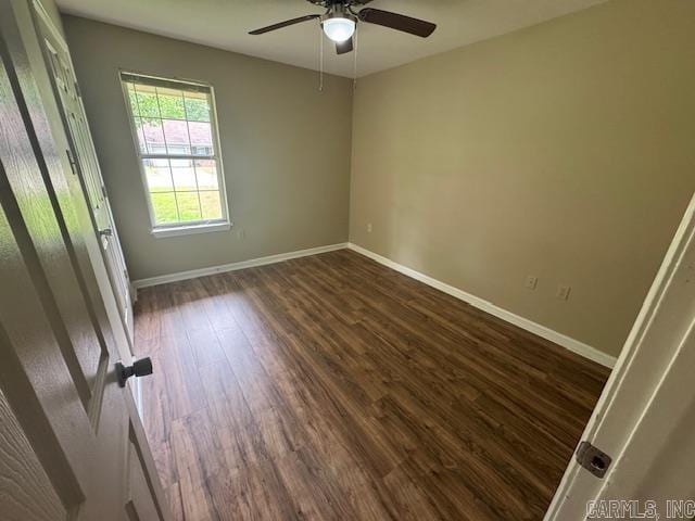 unfurnished bedroom featuring baseboards, dark wood-style floors, and a ceiling fan