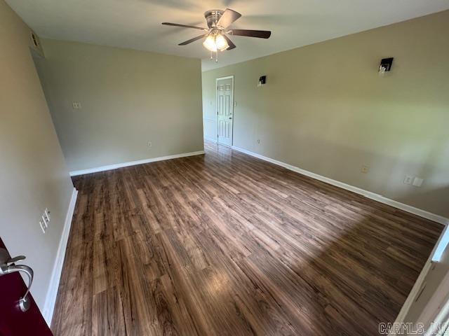 unfurnished room with a ceiling fan, baseboards, and wood finished floors