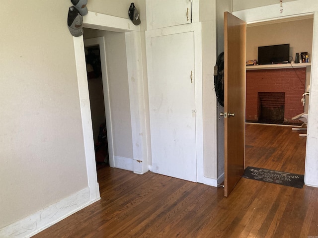 207 11th St, Mena, AR 71953 - unfurnished bedroom featuring a fireplace and wood finished floors