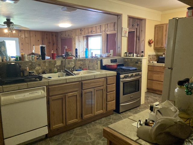 207 11th St, Mena, AR 71953 - kitchen featuring white appliances, a sink, a ceiling fan, healthy amount of natural light, and ornamental molding
