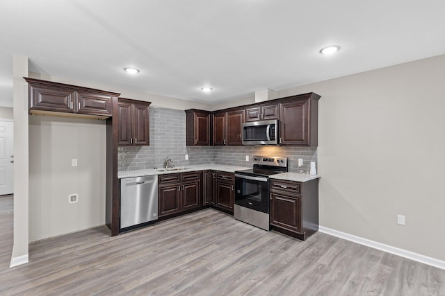 1914 Dennison St, Little Rock, AR 72202 - kitchen featuring backsplash, light wood-style flooring, appliances with stainless steel finishes, and dark brown cabinetry