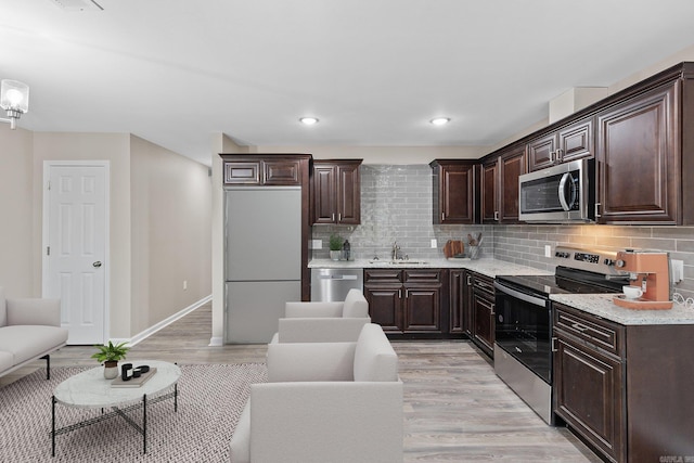 1914 Dennison St, Little Rock, AR 72202 - kitchen featuring dark brown cabinetry, light wood-style floors, stainless steel appliances, and a sink