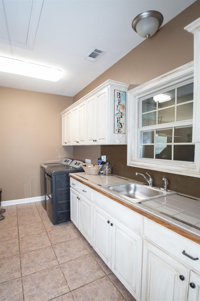 102 Cordell Rd, Beebe, AR 72012 - laundry area featuring light tile patterned floors, a sink, cabinet space, washing machine and clothes dryer, and visible vents