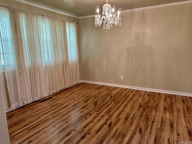 empty room with baseboards, a chandelier, visible vents, and wood finished floors