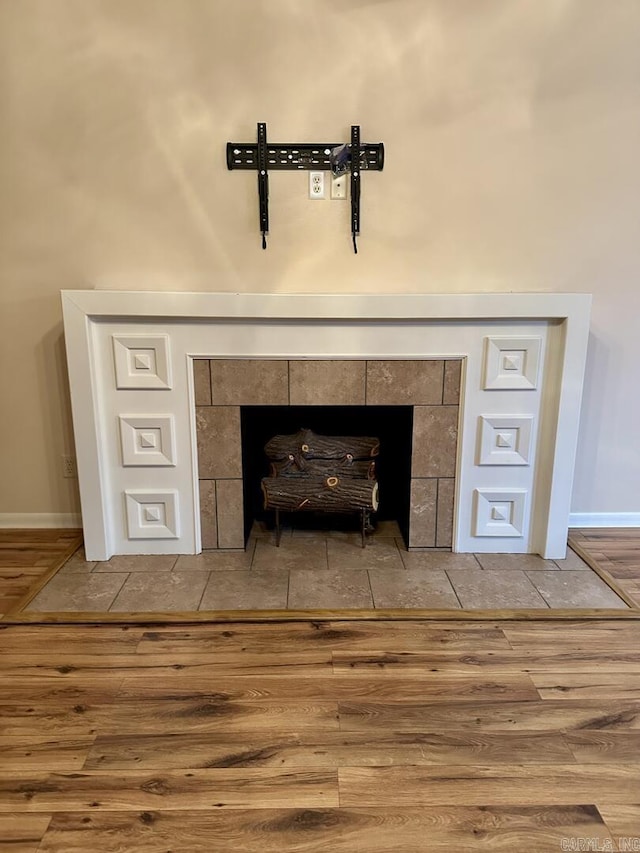 room details with a wood stove, baseboards, and wood finished floors