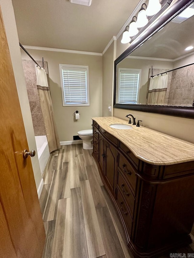 full bathroom featuring toilet, wood finished floors, vanity, ornamental molding, and baseboards