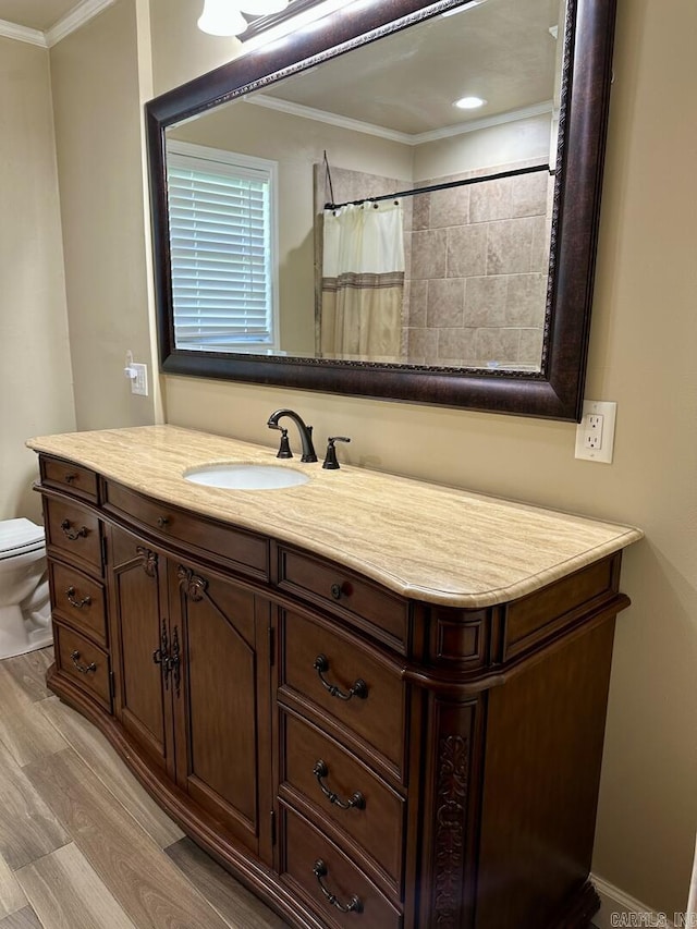 full bathroom featuring toilet, ornamental molding, vanity, and wood finished floors