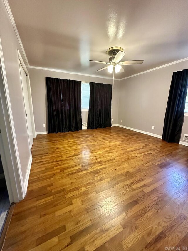 unfurnished bedroom with crown molding, baseboards, ceiling fan, and wood finished floors