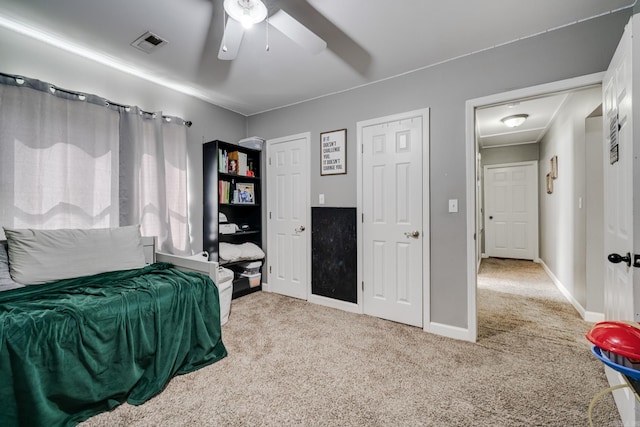 carpeted bedroom featuring visible vents, baseboards, and ceiling fan