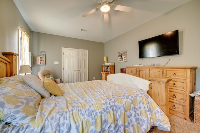 carpeted bedroom featuring a closet, a ceiling fan, and visible vents