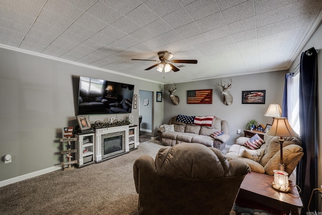 living room featuring crown molding, baseboards, ceiling fan, and carpet floors