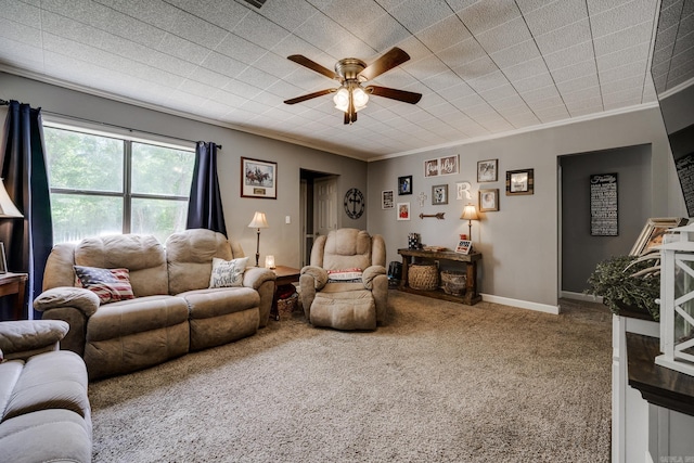 carpeted living area with ceiling fan, crown molding, and baseboards