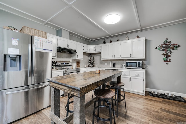 kitchen featuring light wood-style flooring, under cabinet range hood, light countertops, white cabinets, and appliances with stainless steel finishes