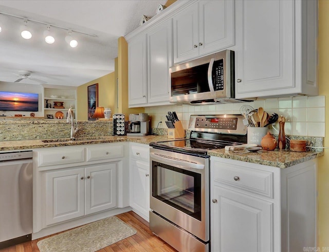 kitchen featuring white cabinetry, light wood finished floors, appliances with stainless steel finishes, and a sink