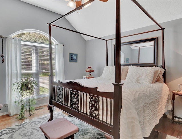bedroom featuring lofted ceiling, wood finished floors, visible vents, and multiple windows