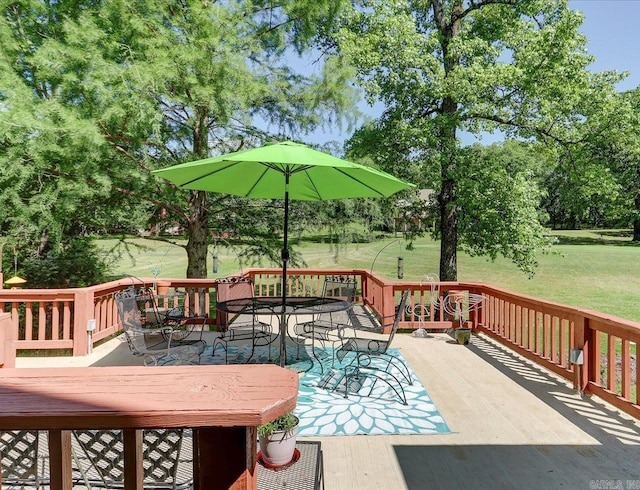 wooden terrace featuring a lawn and outdoor dining area