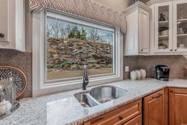74 Greystone Blvd, Cabot, AR 72023 - kitchen featuring a sink, tasteful backsplash, light stone counters, and glass insert cabinets
