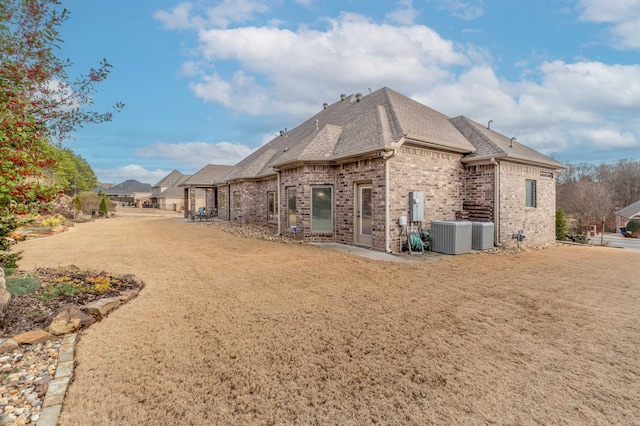 74 Greystone Blvd, Cabot, AR 72023 - rear view of house with central air condition unit, brick siding, and roof with shingles
