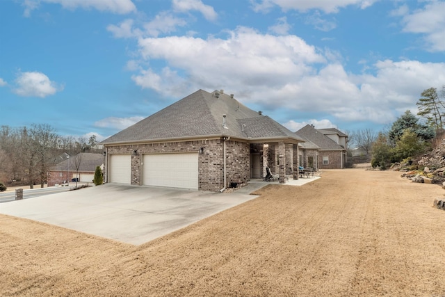 74 Greystone Blvd, Cabot, AR 72023 - view of property exterior with concrete driveway, a shingled roof, brick siding, and an attached garage