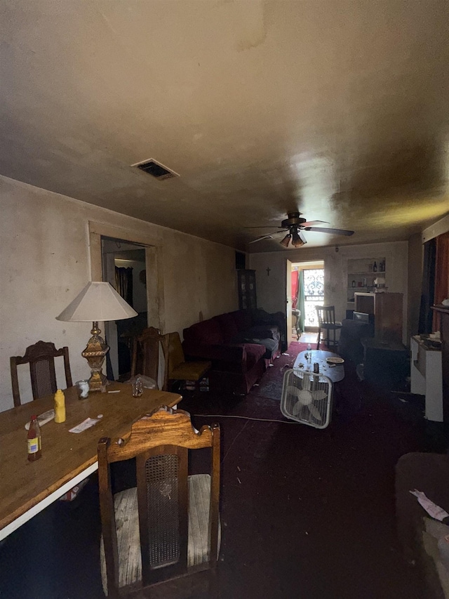 living area with a ceiling fan and visible vents