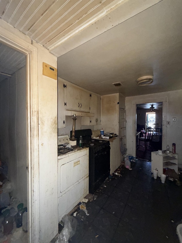 kitchen featuring white cabinetry, visible vents, washer / dryer, light countertops, and gas stove