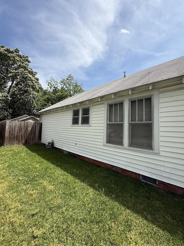back of house featuring a yard and fence