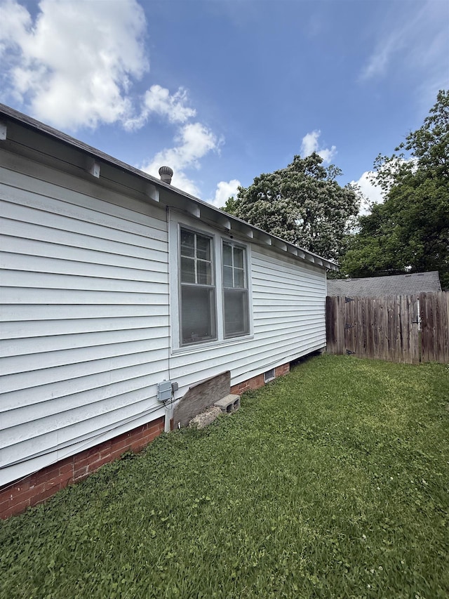 view of side of property featuring a yard and fence