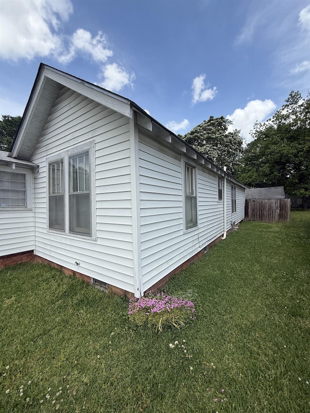 view of property exterior featuring a yard, fence, and crawl space