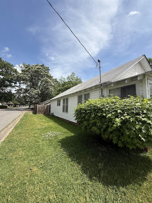 view of side of property featuring a yard and fence