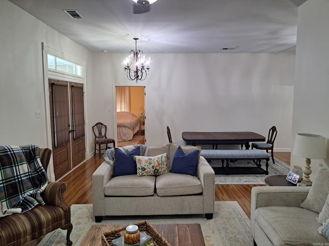 320 E 4th St, Lonoke, AR 72086 - living room featuring an inviting chandelier, baseboards, visible vents, and wood finished floors