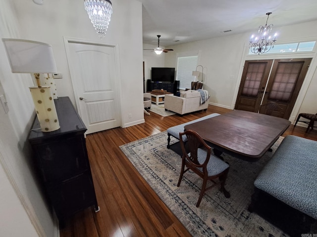 320 E 4th St, Lonoke, AR 72086 - dining area with wood finished floors, french doors, baseboards, and ceiling fan with notable chandelier