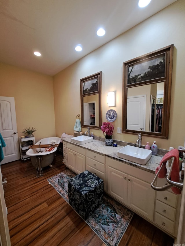 320 E 4th St, Lonoke, AR 72086 - full bathroom with double vanity, a sink, and wood finished floors