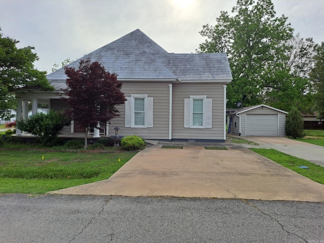 320 E 4th St, Lonoke, AR 72086 - view of front of home with an outdoor structure, driveway, a front yard, and a detached garage