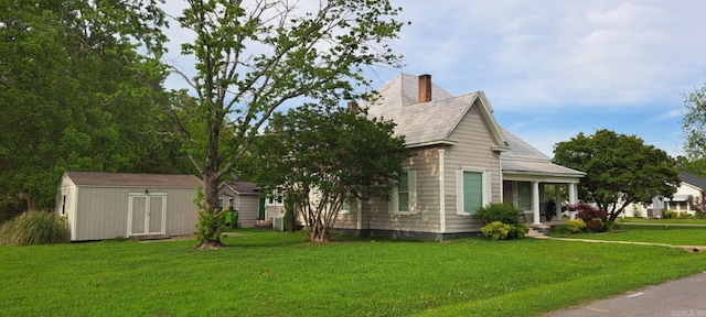 320 E 4th St, Lonoke, AR 72086 - view of side of property featuring a lawn, a chimney, an outbuilding, and a storage unit
