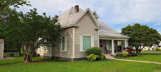 320 E 4th St, Lonoke, AR 72086 - exterior space featuring a yard, a chimney, and covered porch